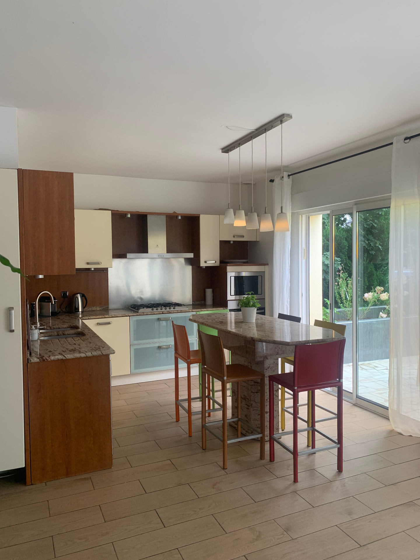 Cuisine ouverte du F3 rez-de-jardin avec îlot central et accès terrasse