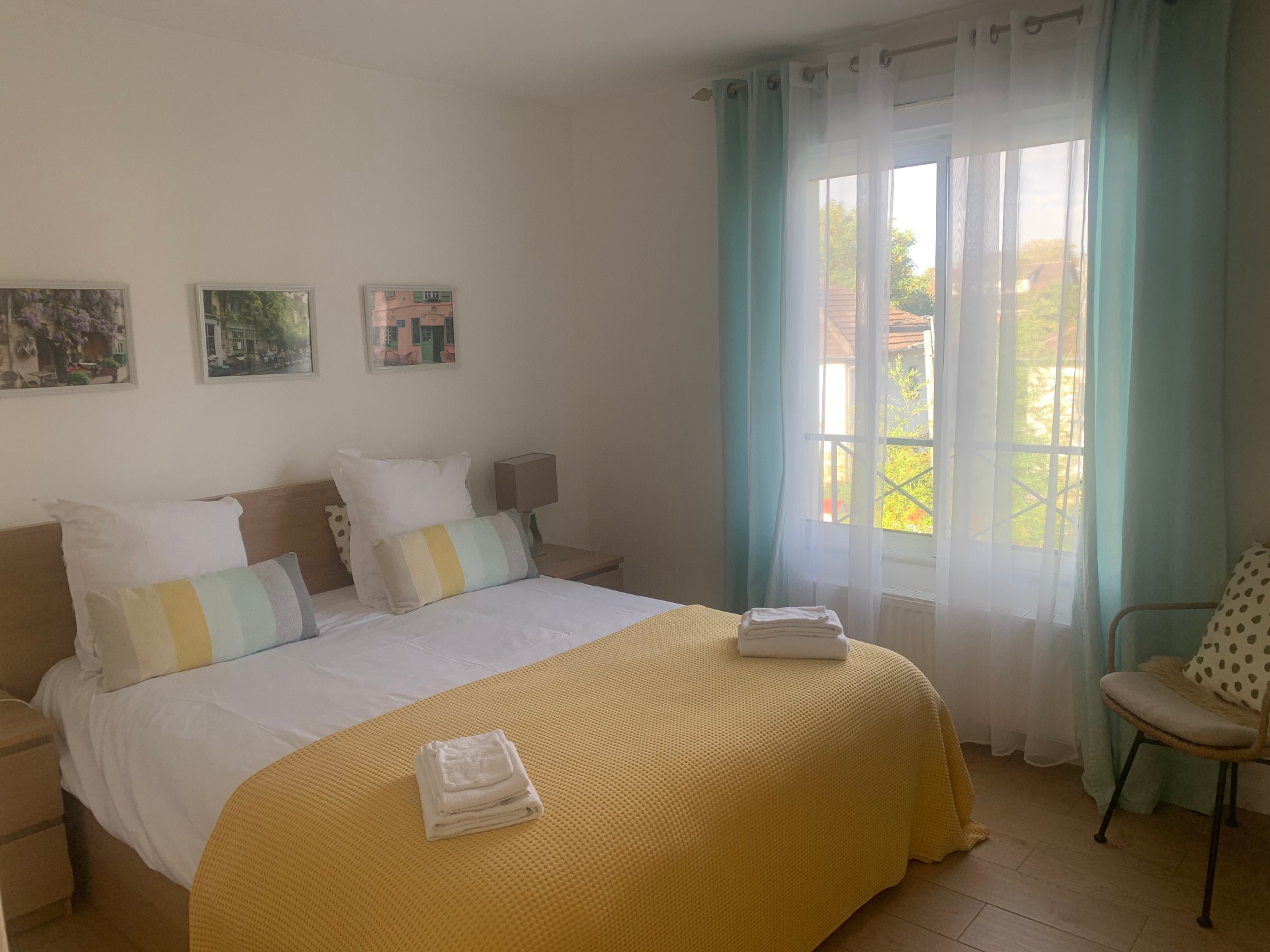 Chambre du studio F1 avec lit double et couvre-lit jaune